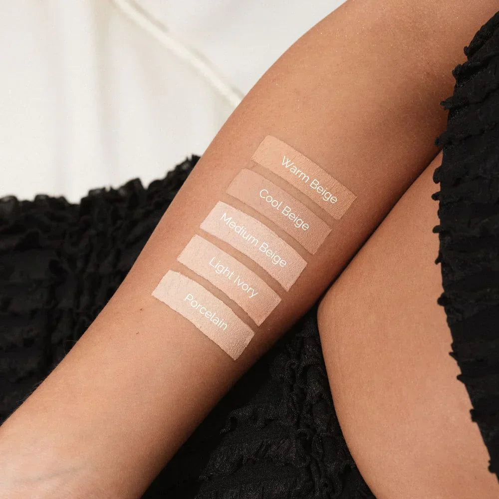 Foundation swatches on arm: Warm Beige, Cool Beige, Medium Beige, Light Ivory, Porcelain shades