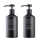 Two black pump bottles of hand and body lotion and wash, showing product descriptions on the back.